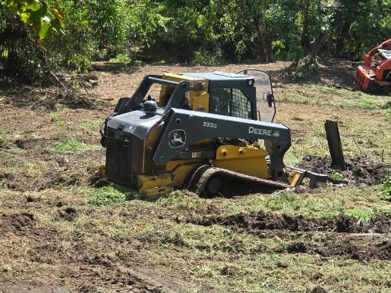 Compact track loader on freshly cleared Northeastern Oklahoma ground